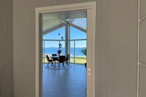 a dining room with a table and a view of the ocean at Oceanfront Infinity Lodge, Lofoten in Vestvågøya
