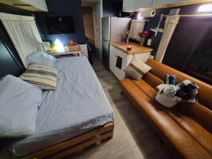 a small bedroom with a bed and a kitchen at Knot Work Cayuga Lake 30ft Boat in Ithaca