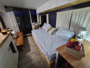 a bedroom with a bed and a table with fruit on it at Knot Work Cayuga Lake 30ft Boat in Ithaca