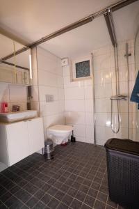 a bathroom with a sink and a toilet in it at Villa floor with patio in Södertälje +2 photos