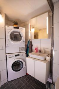 a small bathroom with a washing machine and a sink at Villa floor with patio in Södertälje