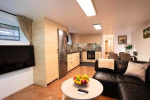 a living room with a couch and a table with a bowl of fruit at Villa floor with patio in Södertälje