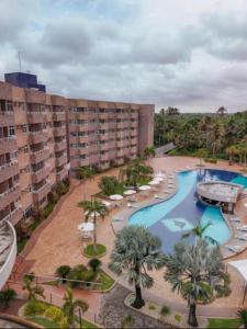 a resort with a pool and palm trees and buildings at Gran Lençóis Flat Residence Barreirinhas in Barreirinhas