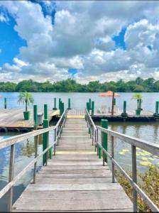 a dock with a boat on a lake at Gran Lençóis Flat Residence Barreirinhas in Barreirinhas