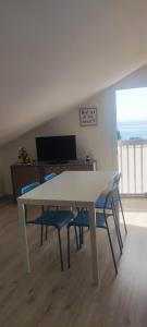 a white table with two blue chairs in a room at La Petite in Cogoleto +4 photos