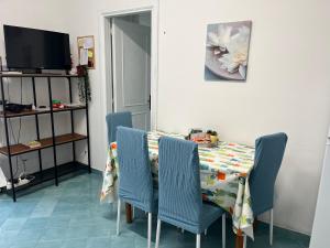 a dining room with a table with blue chairs at Casetta Forio in Forio d'Ischia