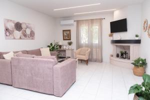 a living room with two couches and a fireplace at La Casa Seni Near Athens Airport in Papangeláki