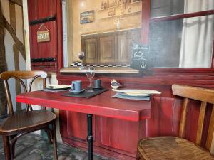 a red bar with a table in a restaurant at La Poupardoise in Honfleur +27 photos