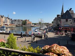 a group of people walking around a marina with boats at La Poupardoise in Honfleur
