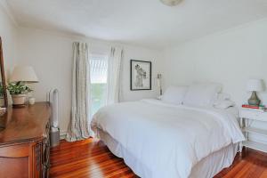 a white bedroom with a large bed and a desk at The Mariposa in Staunton