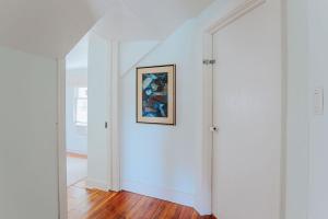 a white hallway with a painting on the wall at The Mariposa in Staunton