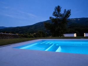 a blue swimming pool with a mountain in the background at Villa Alzira in Seia