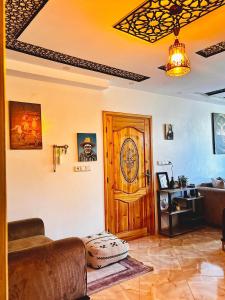 a living room with a wooden door and a couch at Garden view double room in Agadir