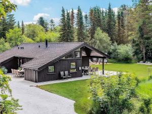 a large wooden house with a patio in a yard at 5 star holiday home in Bindslev in Bindslev