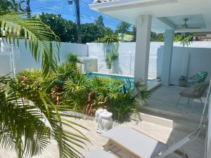 a patio with plants and a swimming pool at Samui Serenity 63 Pool Villa in Choeng Mon Beach