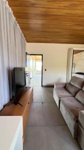 a living room with a couch and a flat screen tv at Casa de Chame Refúgio da Serra in Brasília +70 photos