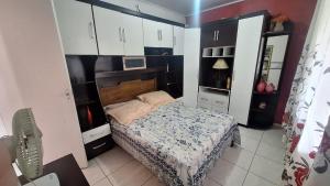 a small bedroom with a bed and white cabinets at Sítio do piu in Lombas +18 photos