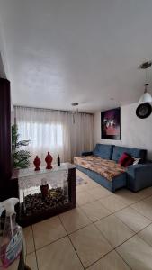 a living room with a blue couch and a bed at Sítio do piu in Lombas