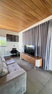 a living room with a couch and a flat screen tv at Casa de Chame Refúgio da Serra in Brasília