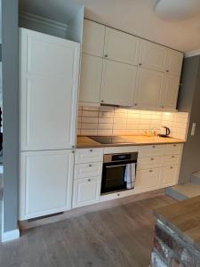 a kitchen with white cabinets and a stove at Krøgeneslåven Microtel in Arendal
