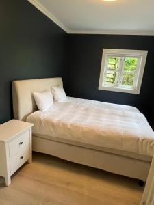 a bedroom with a bed and a window at Krøgeneslåven Microtel in Arendal