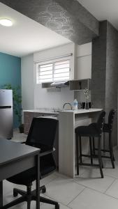 a kitchen with two chairs and a table and a counter at Suites André Confort Ejecutivo in Aguascalientes
