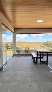 a large room with a table and two chairs on a balcony at Casa de Chame Refúgio da Serra in Brasília