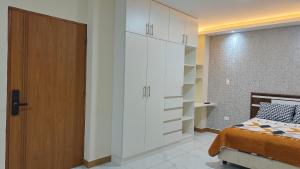a bedroom with a bed and a large white closet at Hospedaje Smart Wasi Sucre in Sucre