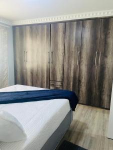 a bedroom with a large bed with wooden cabinets at R&N Hosts in Maseru