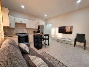 a living room with a couch and a kitchen at Sunset Apartment in Grand Anse
