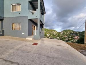 a house on a hill with a driveway at Sunset Apartment in Grand Anse