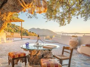a patio with a table and chairs under a tree at Villa Maestoso in Mirsíni
