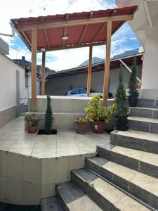 a patio with stairs and a pavilion with potted plants at Amazing Home - Habitación Triple in Baños