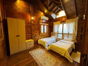 a bedroom with two beds in a wooden cabin at اكواخ اليمامة in Al Baha +40 photos
