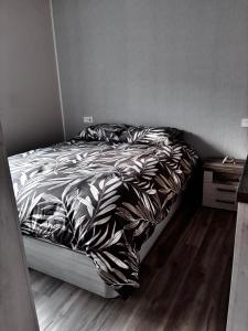 a bedroom with a bed with black and white comforter at Villa Calhia in León