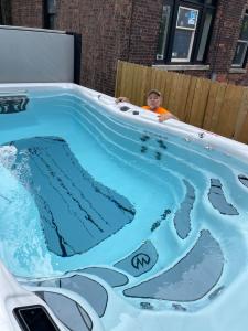 a boy sitting in a jacuzzi bathtub at Buffalo Guesthouse in Buffalo