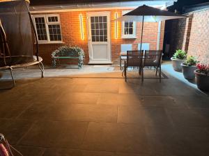 a patio with a table and chairs and an umbrella at Gatwick LUXURY STUDIO FLAT in Crawley