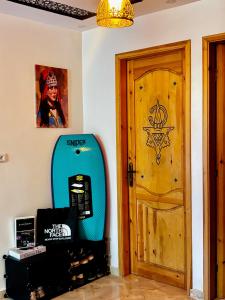 a room with a blue surfboard next to a door at Garden view double room in Agadir