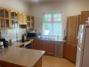 a kitchen with wooden cabinets and a sink and a refrigerator at Armidale Central Guest House in Armidale +11 photos