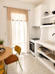 une cuisine avec une table, une cuisinière et une fenêtre dans l'établissement Maya Mallis, à Adamas