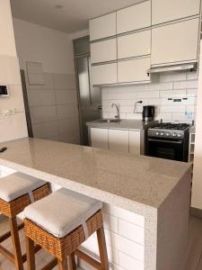 a kitchen with a granite counter top and stools at Punta Hermosa Apartment in Punta Hermosa