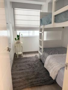 a bedroom with a bunk bed and a rug at Punta Hermosa Apartment in Punta Hermosa