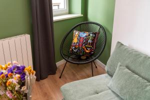 a black chair with a colorful pillow in a living room at Le Nid d'HAG in Haguenau +28 photos