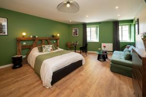 a bedroom with green walls and a bed and a couch at Le Nid d'HAG in Haguenau