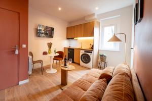 a living room with a couch and a kitchen at Le Nid d'HAG in Haguenau
