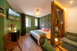 a bedroom with green walls and a bed and a couch at Le Nid d'HAG in Haguenau