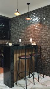 a kitchen with two bar stools and a brick wall at Loft urbano in Martins