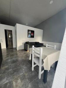 a dining room with a white table and a couch at Tu rincón, lugar de descanso in Chascomús