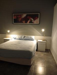 a bedroom with a bed and two night stands with lamps at Tu rincón, lugar de descanso in Chascomús