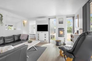 a living room with a couch and a tv at FY147-Middelfart-Antaresvej-6 in Middelfart